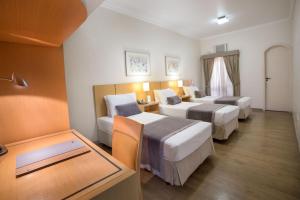 Habitación de hotel con 2 camas y mesa en Cardum Hotel, en Sorocaba
