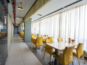 a dining room with yellow chairs and tables and windows at Jinjiang Inn Tianjin Zhongshan Road in Tianjin