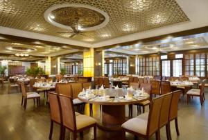 un restaurant avec des tables et des chaises dans une salle dans l'établissement International Asia-Pacific Convention Center, à Sanya
