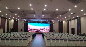 a large banquet hall with white chairs and a stage at Qingdao Blue Horizon Hotel Huangdao in Huangdao