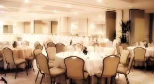 une salle de conférence avec des tables et des chaises blanches dans l'établissement Hotel Veniz, à Baguio