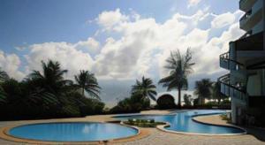 a resort with two swimming pools and palm trees at BP Samila Beach Hotel & Resort in Songkhla
