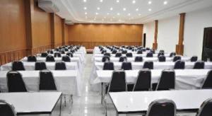a large conference room with white tables and black chairs at Piyaporn Hill Paradise Hotel in Mae Sai