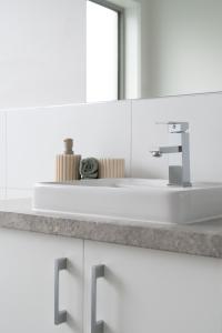 een badkamer met een witte wastafel en een spiegel bij Villa Tranquillità in Venus Bay
