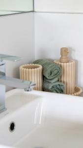 een stapel handdoeken bovenop een wastafel in de badkamer bij Villa Tranquillità in Venus Bay +25 foto's