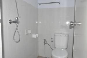 a white bathroom with a shower and a toilet at Bubu Inn in Ubud