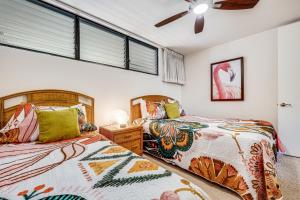 una camera da letto con due letti e un ventilatore a soffitto di Papakea Resort Unit J303 a Lahaina