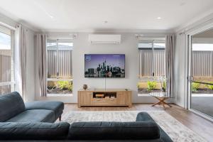 ein Wohnzimmer mit Sofa und Fernseher in der Unterkunft Large Mandogalup Family Retreat in Banjupp Station