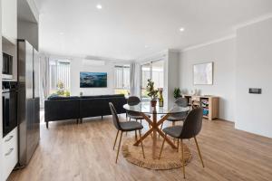 eine Küche und ein Wohnzimmer mit Tisch und Stühlen in der Unterkunft Large Mandogalup Family Retreat in Banjupp Station