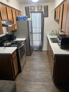 a kitchen with a sink and a refrigerator at Cozy hostel for individuals in Phoenix