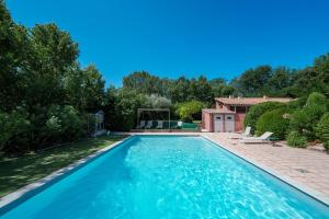 a swimming pool in a yard next to a house at Mano - 4 personnes in Nyons +5 photos