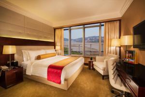 um quarto com uma cama grande e uma janela grande em Broadway Hotel em Macau