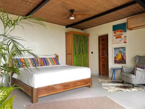 ein Schlafzimmer mit einem Bett und einem Stuhl in der Unterkunft Mar de Uluwatu - Ocean View Villa in Uluwatu