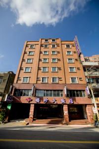 een hoog gebouw met een bord erop bij Ying Zhen Hotel in Taoyuan