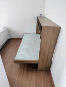 a bed in a room with a wooden desk at Apto inteiro 600mts do Hospital de Amor in Barretos