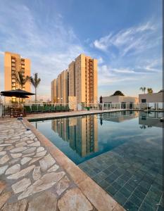 a swimming pool in front of some buildings at Apto inteiro 600mts do Hospital de Amor in Barretos