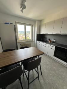 a kitchen with a wooden table and some chairs at Appartement nah zum Zentrum in Dornbirn