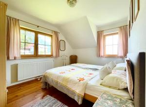 une chambre avec un lit et deux fenêtres dans l'établissement Haus Rosenheim, à Ramsau am Dachstein