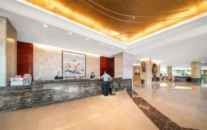 a man standing at a counter in a hotel lobby at Venus Royal Hotel （Kirin Parkview Hotel） in Shatsing +180 photos