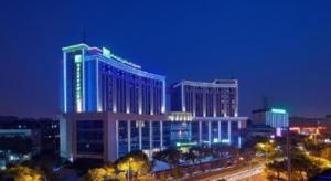 a large building with blue lights on it at night at Holiday Inn Express Nantong Downtown By IHG in Nantong