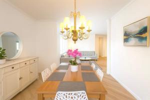 ein Esszimmer mit einem Tisch mit Stühlen und einem Kronleuchter in der Unterkunft Allura Del Mar Heights Pet-Friendly 5BR Retreat in Del Mar