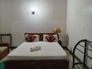 スリ・ジャヤワルダナプラ・コッテにあるSun Hinda Colomboの白いシーツと枕が備わったベッドのある寝室