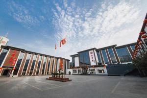 a large building with a flag in front of it at GreenTree Inn Puyang Ruifengyuan Business Hotel in Zhongyuanyoutian
