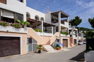 an apartment building with stairs and flower boxes at Casita en Cala Llonga in Cala Llonga