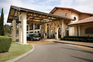 a building with a car parked in a driveway at Chateau Elan At The Vintage in Pokolbin