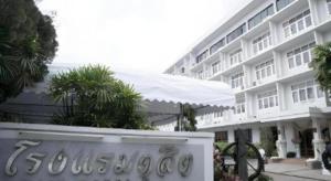 un grand bâtiment blanc avec une enseigne devant dans l'établissement Dusit Hotel, à Sakon Nakhon