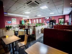 a restaurant with tables and chairs and a bar at GreenTree Inn Luoyang Zhongzheng Street Express Hotel in Luoyang