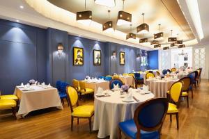 a dining room with tables and yellow chairs at Shanghai Jinchen Hotel in Shanghai