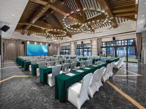 a conference room with green tables and white chairs at Country Garden Hot Spring Hotel Huizhou in Huizhou +261 photos