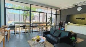 un salon avec un canapé noir et une salle à manger dans l'établissement Seree Grand Resort, à Ban Ho