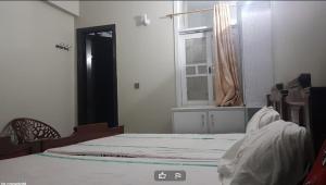 ein leeres Zimmer mit einem Bett und einem Fenster in der Unterkunft High City Hotel in Dargai