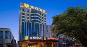 un grand bâtiment avec une enseigne sur le côté dans l'établissement Echeng Hotel Qinzhou Bay Plaza East High-speed Railway Station, à Qinzhou