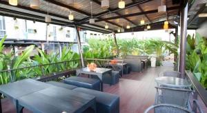 un restaurant avec des tables, des chaises et des plantes dans l'établissement I Hotel, à Ban Noi Pho Kham