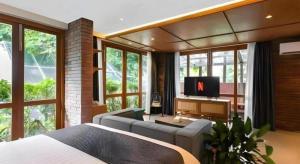 a bedroom with a bed and a tv in a room at The House Tour Middletown in Bandung