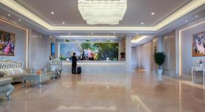 a lobby with a person standing in a room at Vienna Hotel Nanning Xiangsi Lake University Town in Nanning