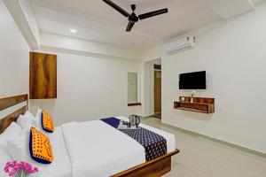 a bedroom with a bed and a flat screen tv at Hotel O Star in Naroda
