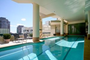 a large swimming pool with a large balcony at The Sebel Sydney Chatswood in Sydney