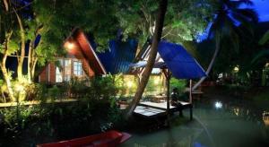 une maison avec un toit bleu à côté d'une piscine dans l'établissement Banmaihom Resort Amphawa, à Wat Phleng