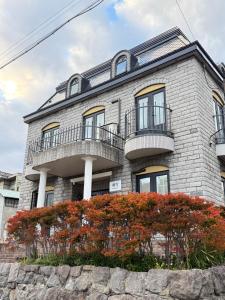 a stone building with balconies and flowers in front at sakurayuki in Otaru