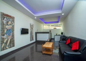 乌提Tulips Valley View Resorts的客厅配有黑色沙发和红色枕头