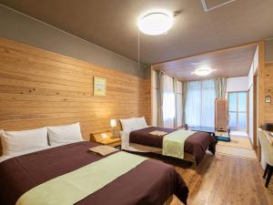een hotelkamer met twee bedden en een raam bij Fontana no Oka Kamou in Aira