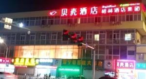 un bâtiment avec un lampadaire devant lui dans l'établissement Shell Jiaxing Nanhu District Dongsheng Dong Road Moon River Street Hotel, à Jiaxing