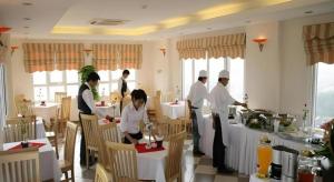 un groupe de personnes dans une cuisine préparant la nourriture dans l'établissement New Moon Hotel, à Hanoï