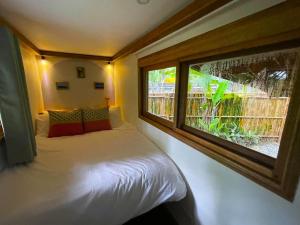 a bedroom with a bed and a large window at Jeepney Siargao in General Luna +34 photos