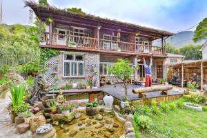 a house with a pond in front of it at Om Yoga Resort in Deqing