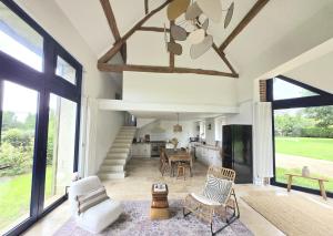 uma sala de estar com uma mesa e cadeiras e um tecto em Longère de charme, calme & piscine em Armentières-sur-Avre